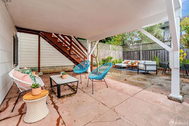 a backyard of a house with barbeque oven table and chairs
