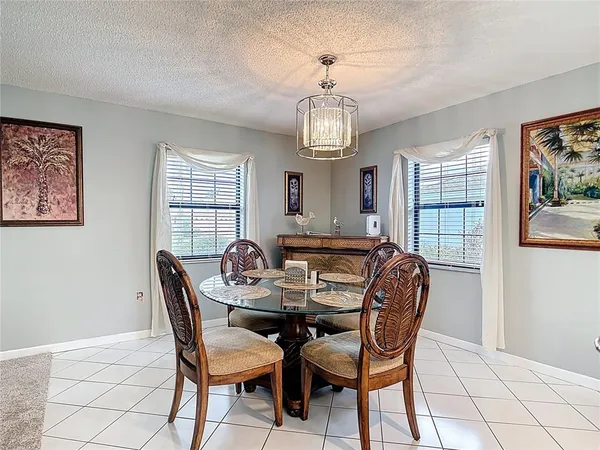 a kitchen with a dining table chairs and white cabinets