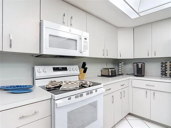 a kitchen with white cabinets and white appliances