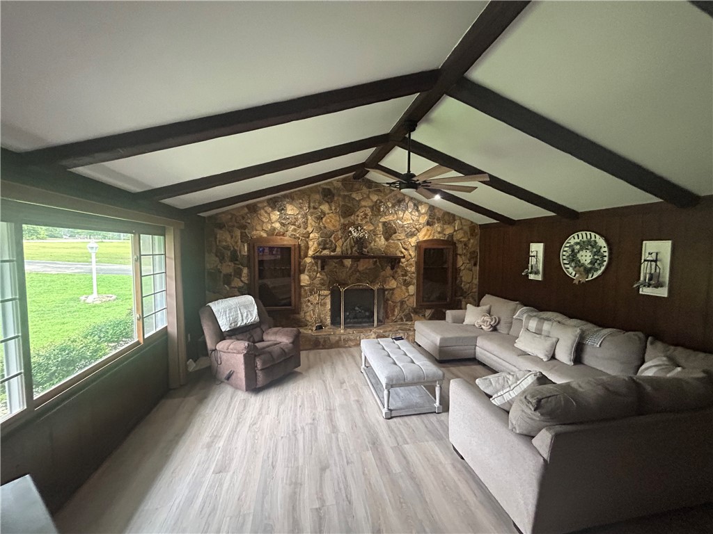 307 Mar-Mac Road Anderson, SC 29626 - Photo 5 of 19 Vaulted ceilings with exposed beams crown this expansive living room, featuring a stone fireplace and sun-filled views.