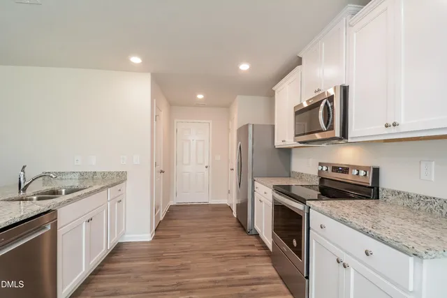 a kitchen with stainless steel appliances granite countertop a sink stove and refrigerator