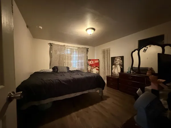 a bedroom with a bed and wooden floor