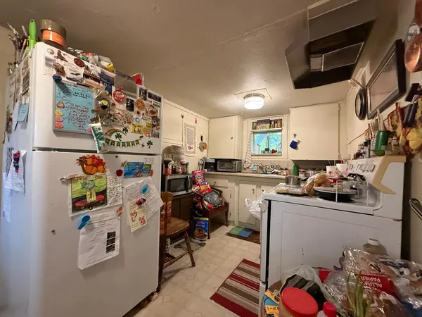 a kitchen with stainless steel appliances granite countertop a stove a sink dishwasher and a dining table with wooden cabinet