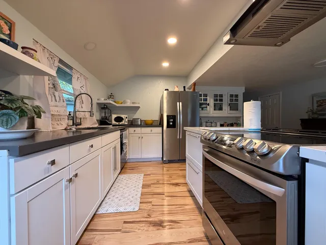 a kitchen with stainless steel appliances a refrigerator and wooden cabinets