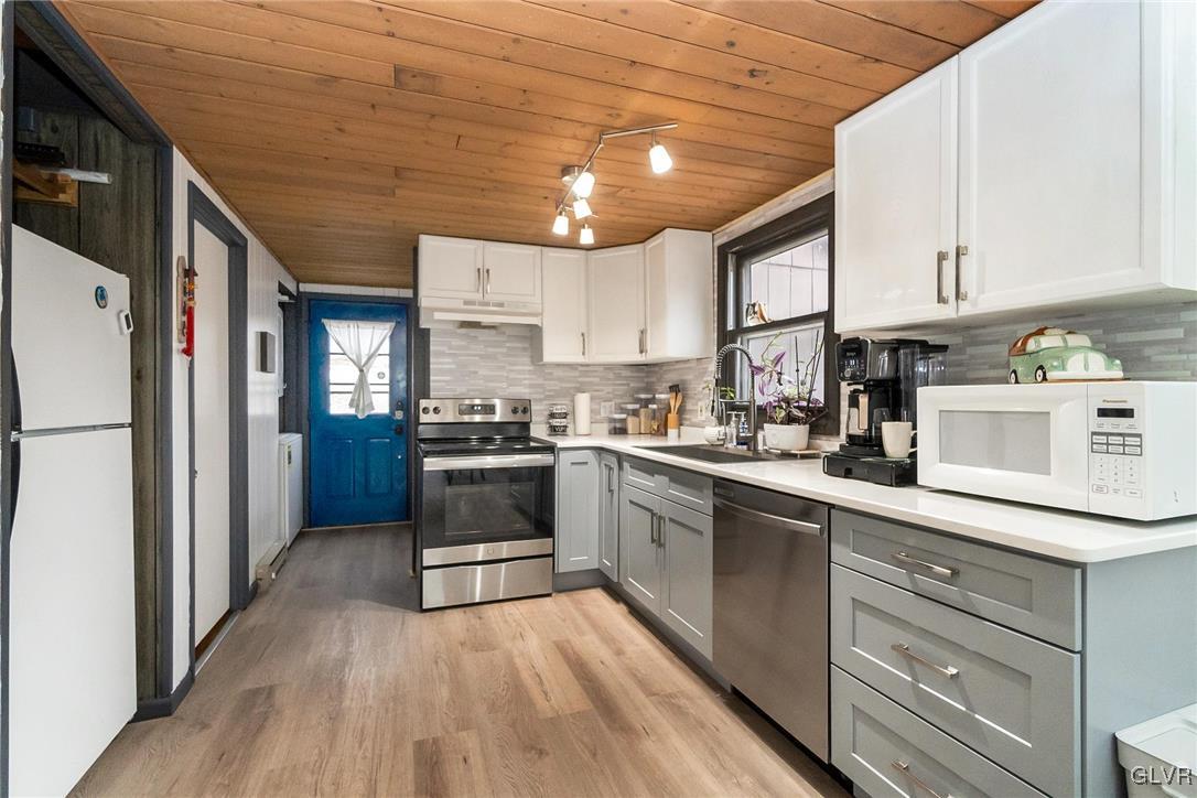 5967 Decker Road Bushkill, PA 18324 - Photo 17 of 47 a kitchen with stainless steel appliances granite countertop a refrigerator a sink dishwasher a stove and white countertops with wooden floor