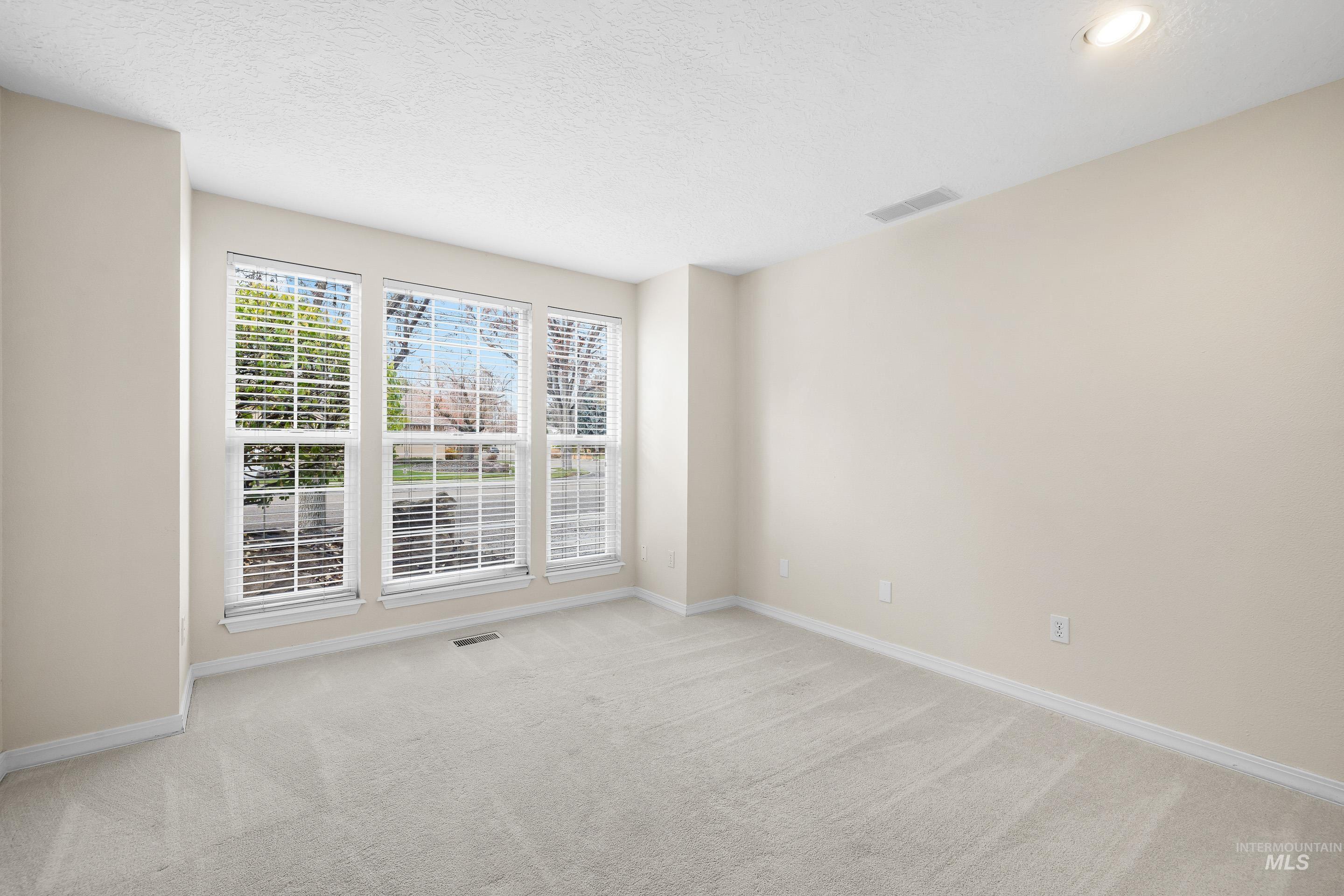 7736 West Bayhill Street Boise, ID 83704 - Photo 22 of 50 Spare room featuring a textured ceiling and light colored carpet
