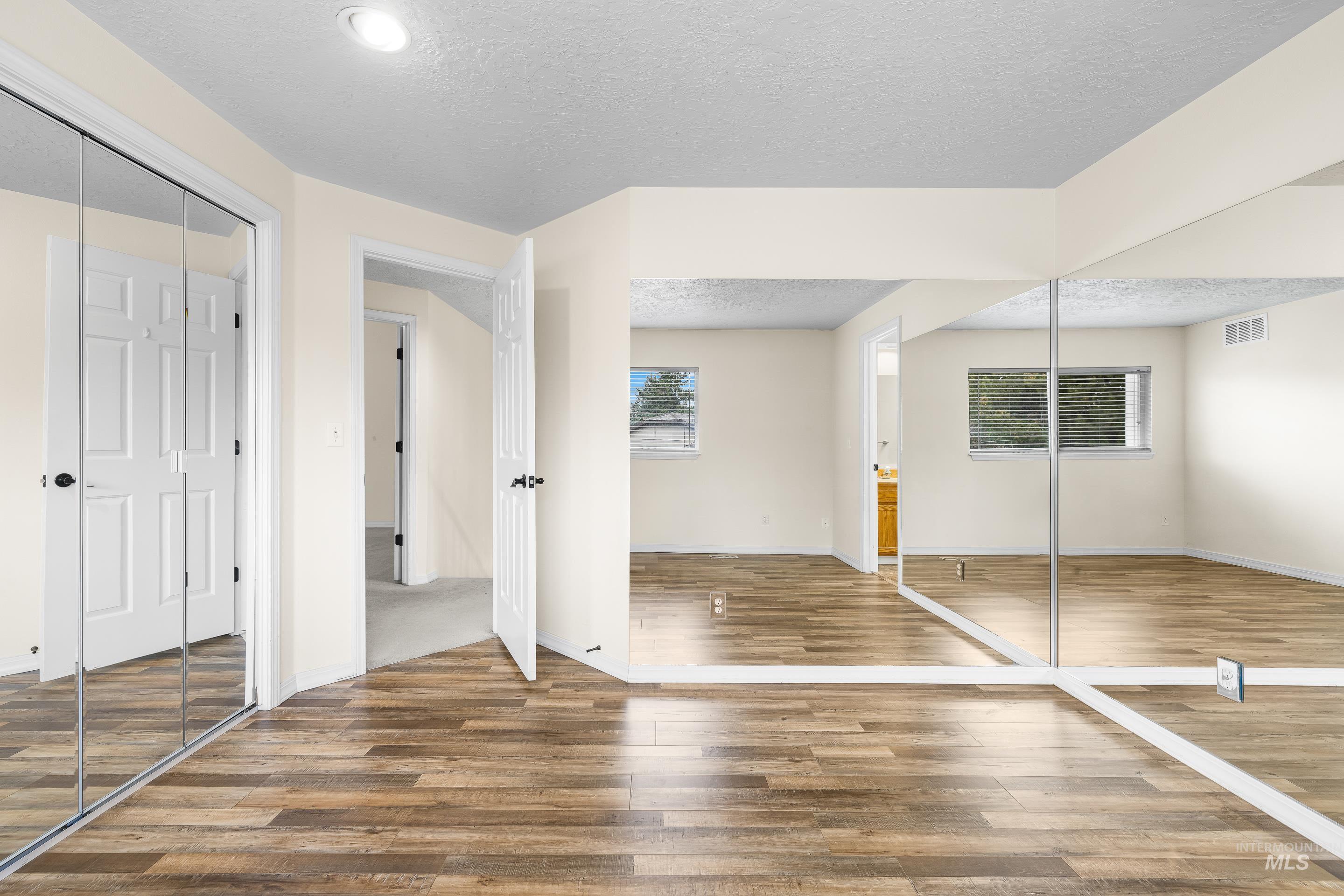 7736 West Bayhill Street Boise, ID 83704 - Photo 36 of 50 Unfurnished bedroom with a closet, a textured ceiling, ensuite bath, and wood finished floors
