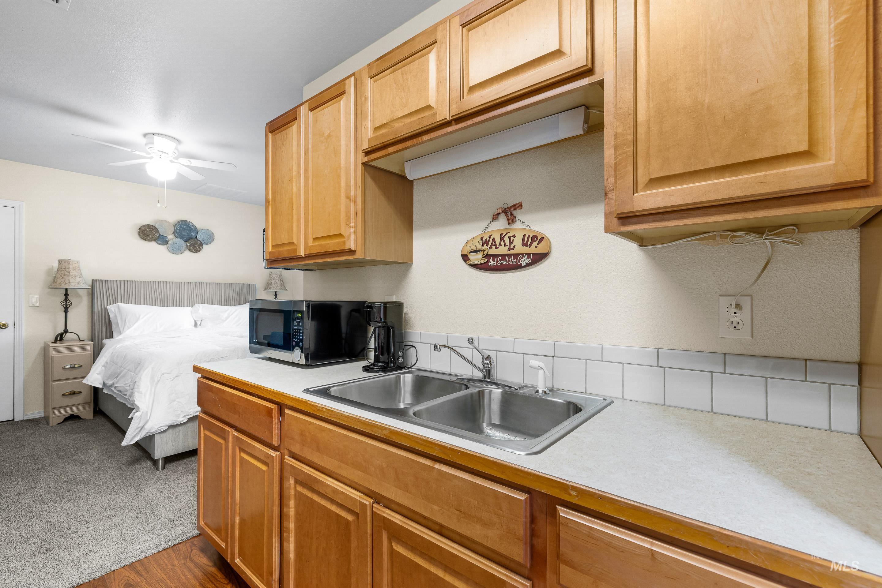7736 West Bayhill Street Boise, ID 83704 - Photo 42 of 50 Kitchen featuring light countertops, stainless steel microwave, a ceiling fan, and dark colored carpet