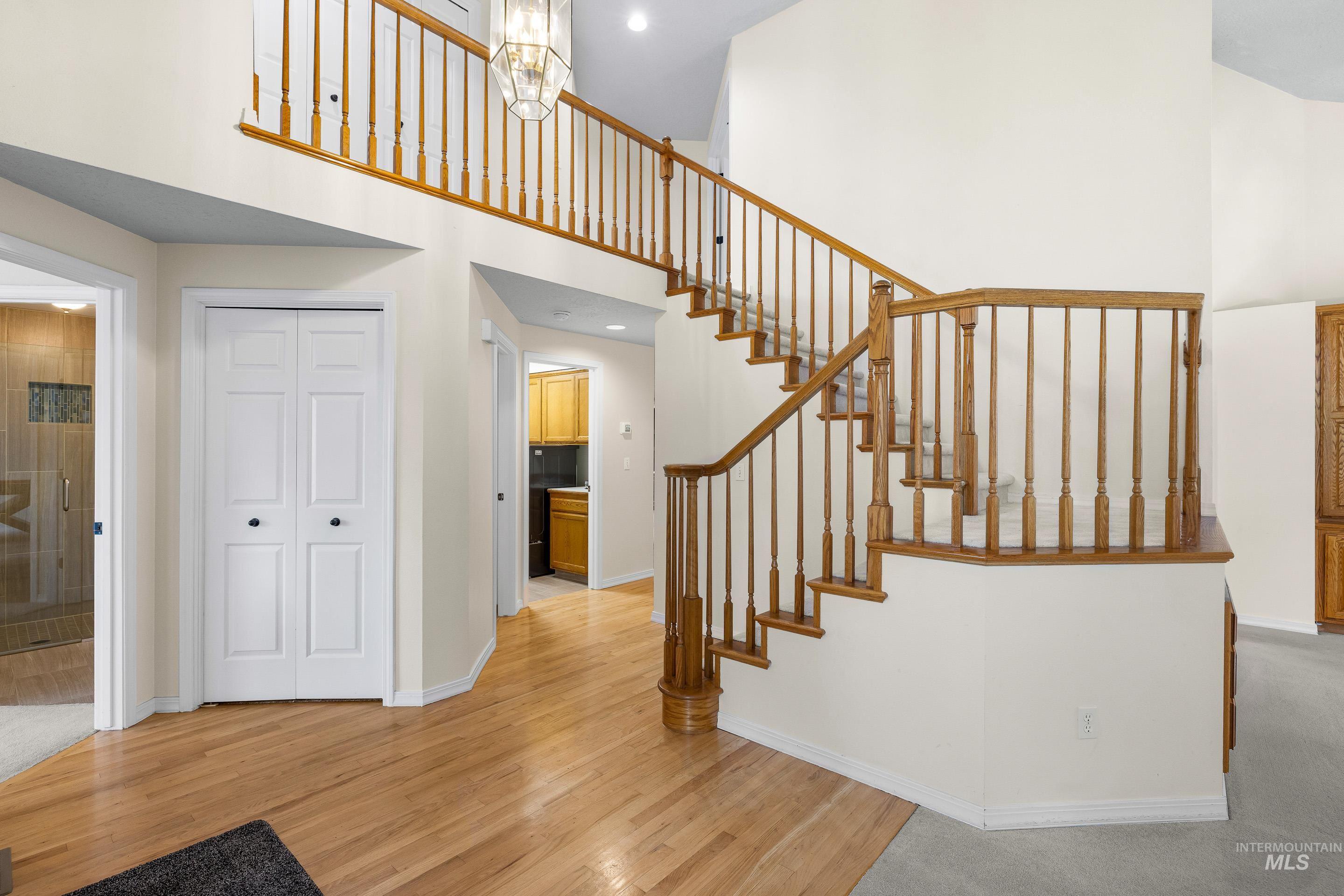 7736 West Bayhill Street Boise, ID 83704 - Photo 9 of 50 Staircase with a towering ceiling and wood finished floors
