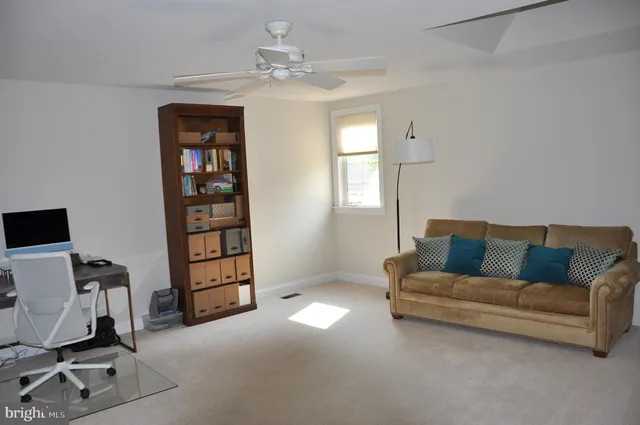 a living room with furniture a chandelier and a window
