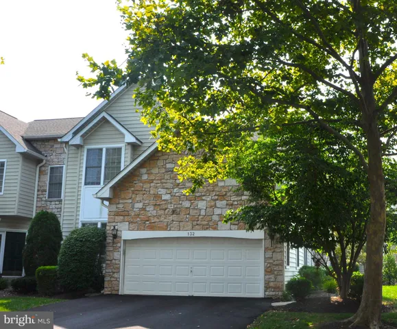 a front view of a house with a garden and plants