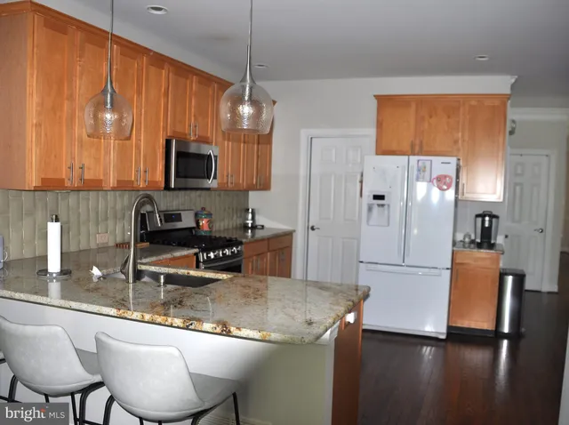 a kitchen with stainless steel appliances granite countertop a sink refrigerator and microwave