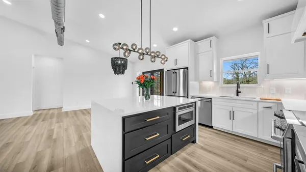 a kitchen with white cabinets and sink