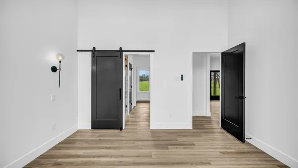 a view of an empty room with wooden floor and closet