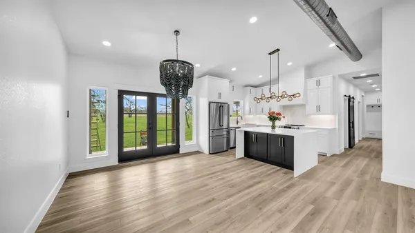 a view of large kitchen with a sink and wooden floor
