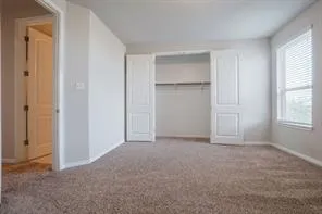 an empty room with windows and closet