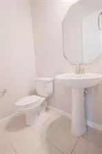 a bathroom with a toilet a sink and mirror