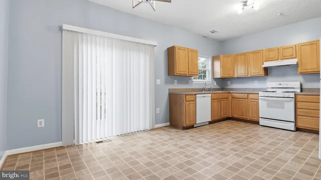 a kitchen with a cabinets a sink a window and stainless steel appliances