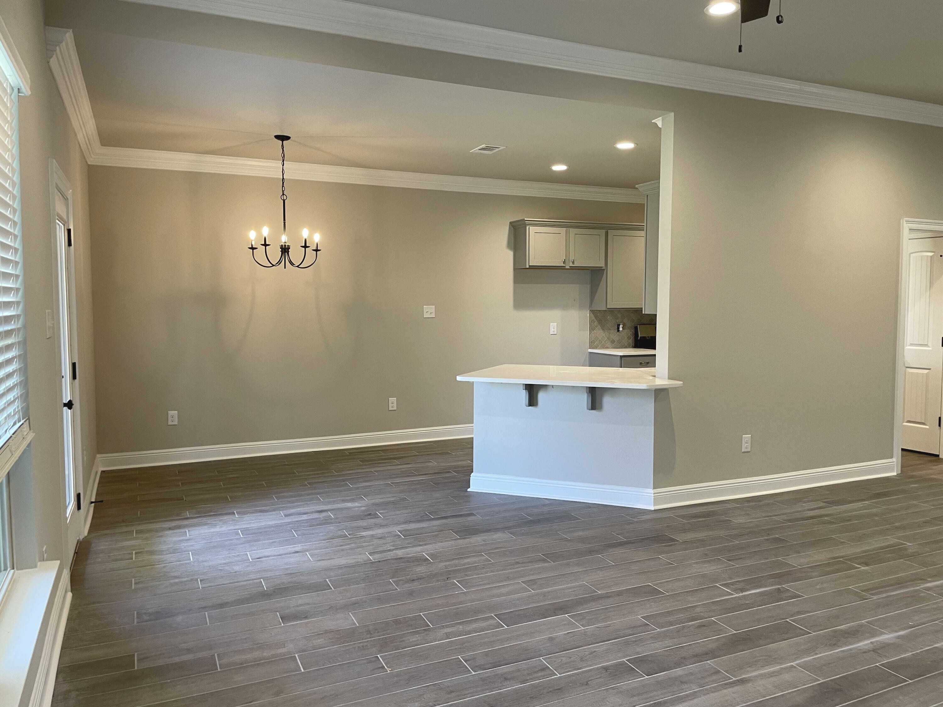 17 Alley Oak Lane Freeport, FL 32439 - Photo 3 of 6 an empty room with wooden floor and kitchen view
