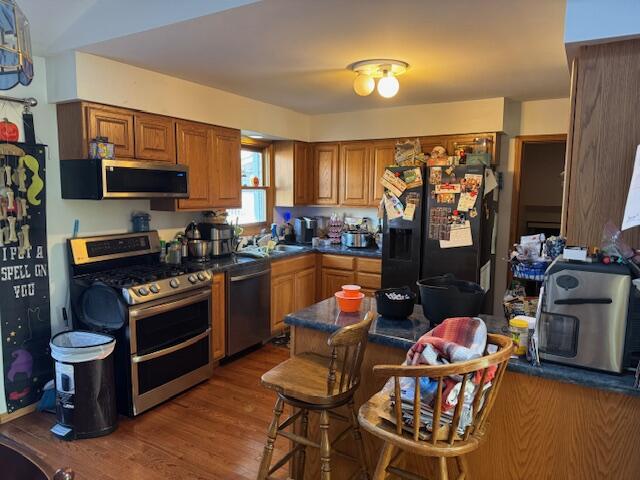 6100 Robbins Road Portage, IN 46368 - Photo 4 of 31 a kitchen with stainless steel appliances a stove a sink dishwasher a dining table and chairs with wooden floor
