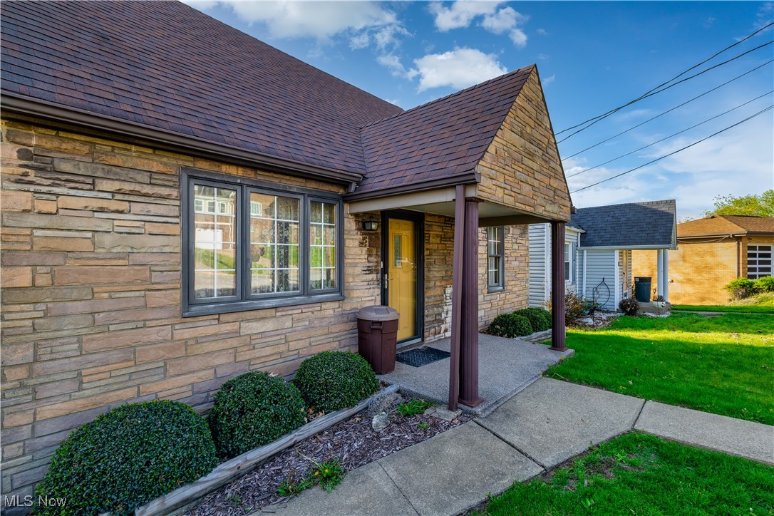 268 Beech Road Weirton, WV 26062 - Photo 5 of 48 View of front of property featuring a shingled roof, stone siding, and a front yard