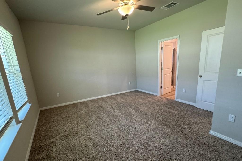 12604 Dairywork Road Buda, TX 78610 - Photo 7 of 20 A well-lit bedroom with plush carpeting, offering a tranquil retreat.