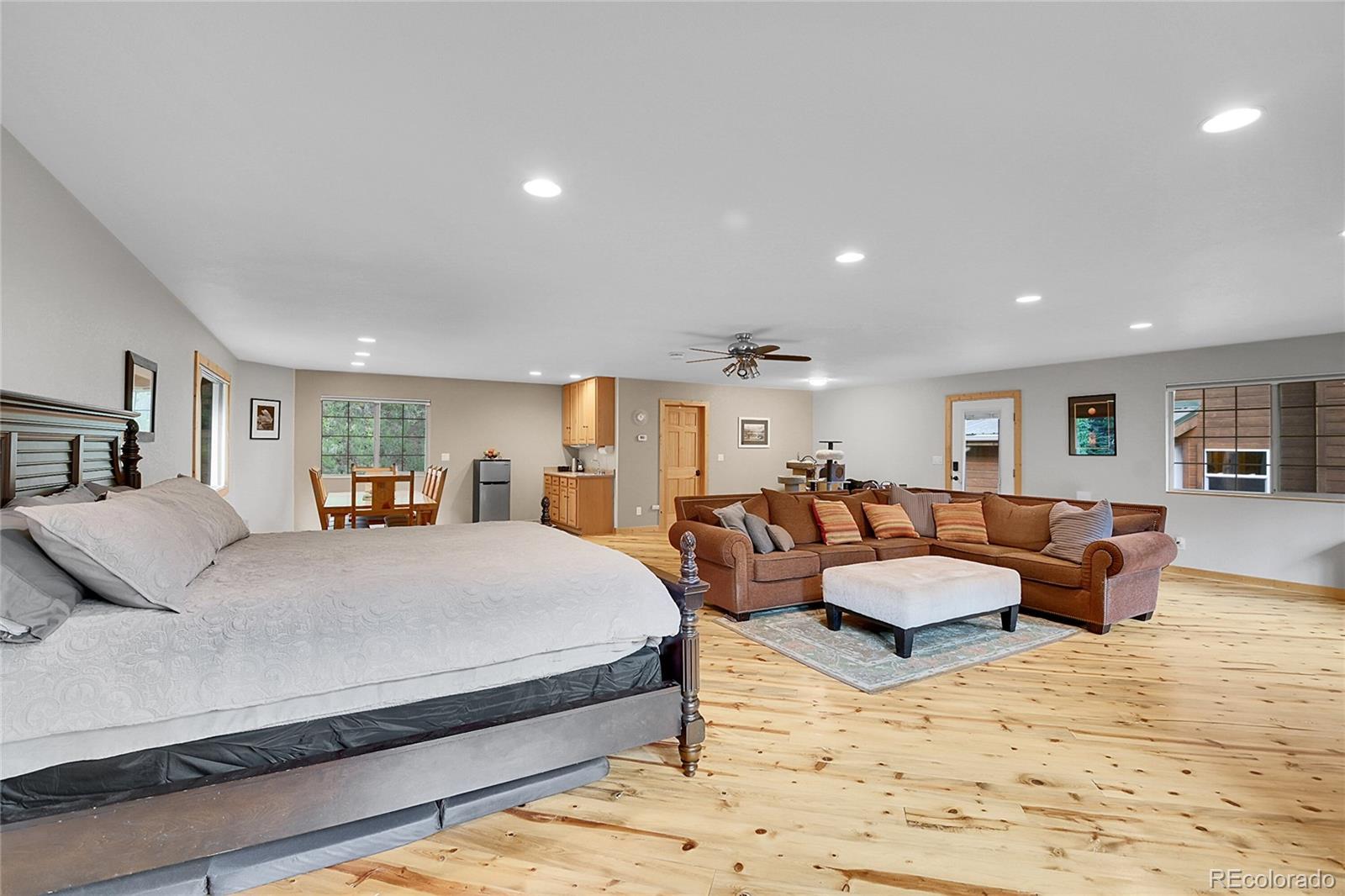 11182 Barney Gulch Road Conifer, CO 80433 - Photo 11 of 50 a spacious bedroom with a large bed and couch