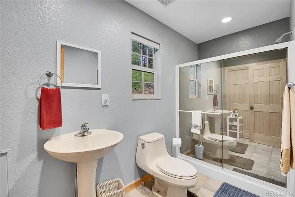 a bathroom with a sink toilet and shower