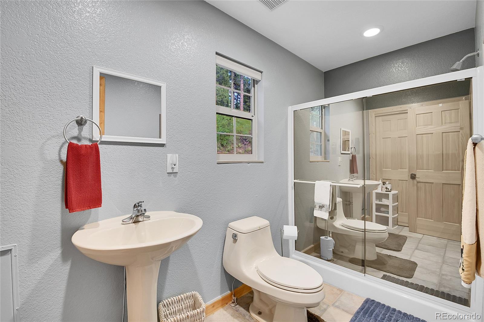 11182 Barney Gulch Road Conifer, CO 80433 - Photo 13 of 50 a bathroom with a sink toilet and shower