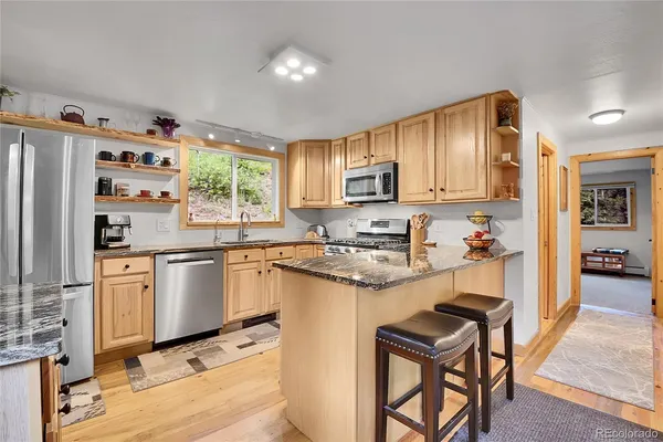 a kitchen with stainless steel appliances granite countertop a refrigerator sink and cabinets