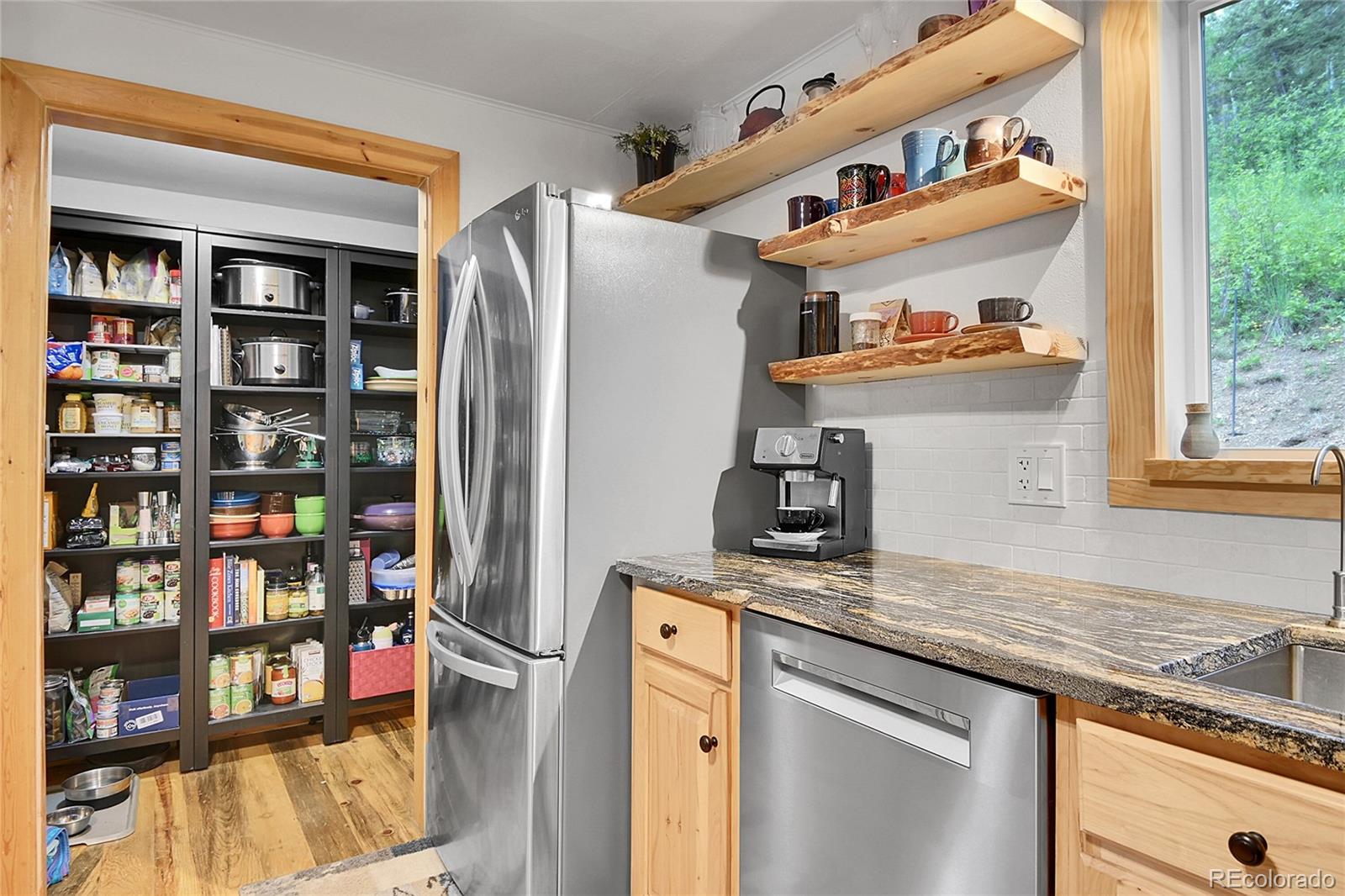 11182 Barney Gulch Road Conifer, CO 80433 - Photo 16 of 50 a kitchen with stainless steel appliances granite countertop a refrigerator and a sink