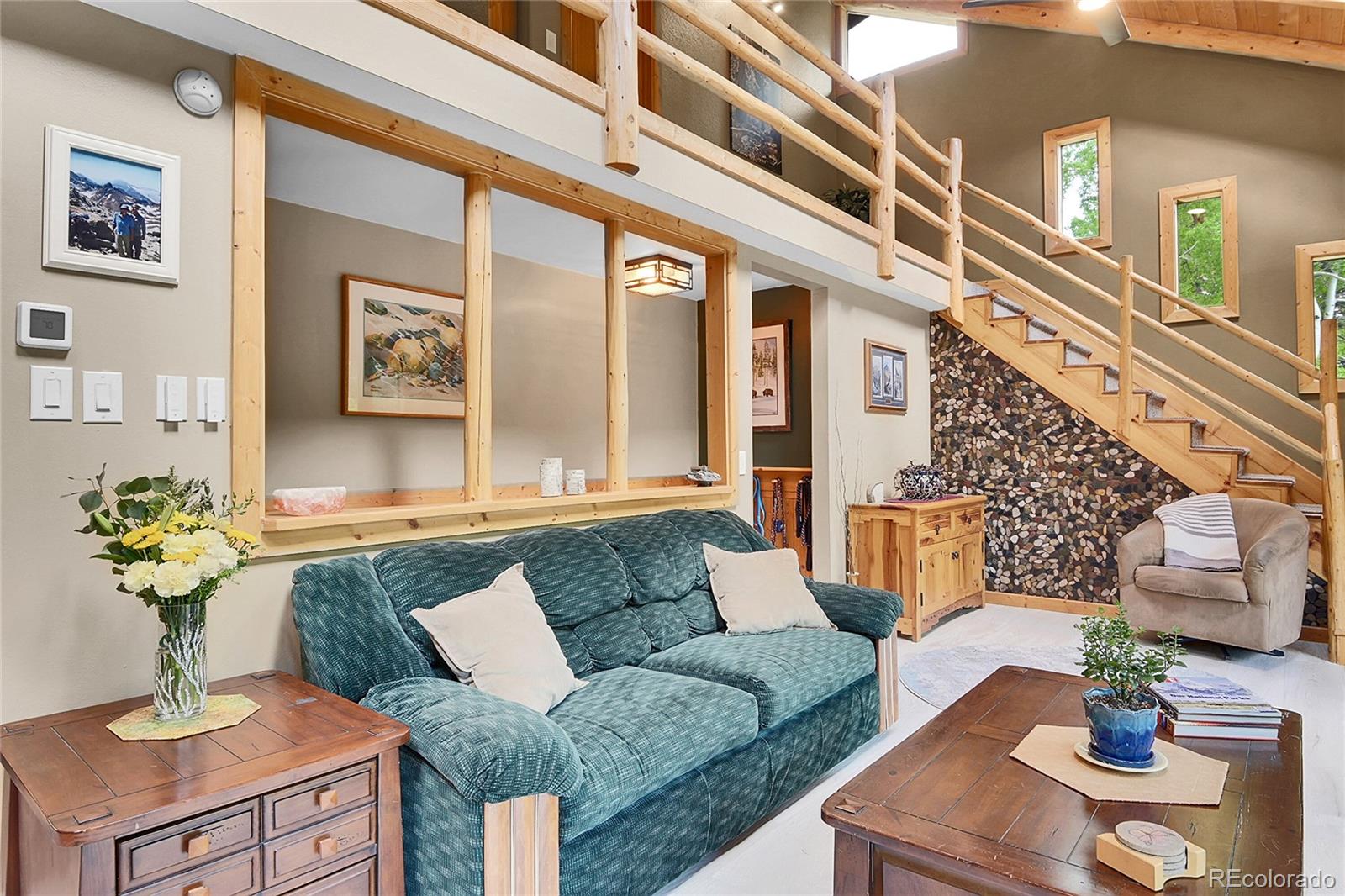 11182 Barney Gulch Road Conifer, CO 80433 - Photo 19 of 50 a living room with furniture and flowers