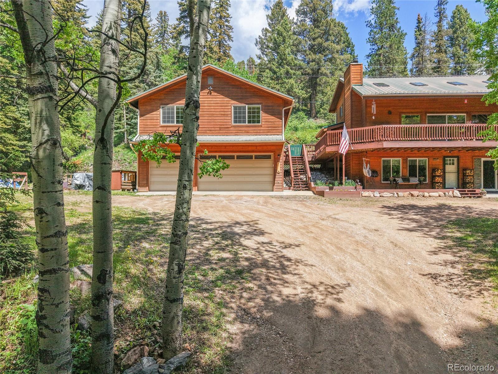 11182 Barney Gulch Road Conifer, CO 80433 - Photo 2 of 50 a front view of a house with a yard