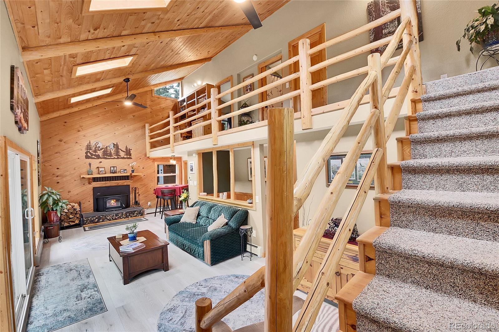 11182 Barney Gulch Road Conifer, CO 80433 - Photo 21 of 50 a living room with furniture and a fireplace