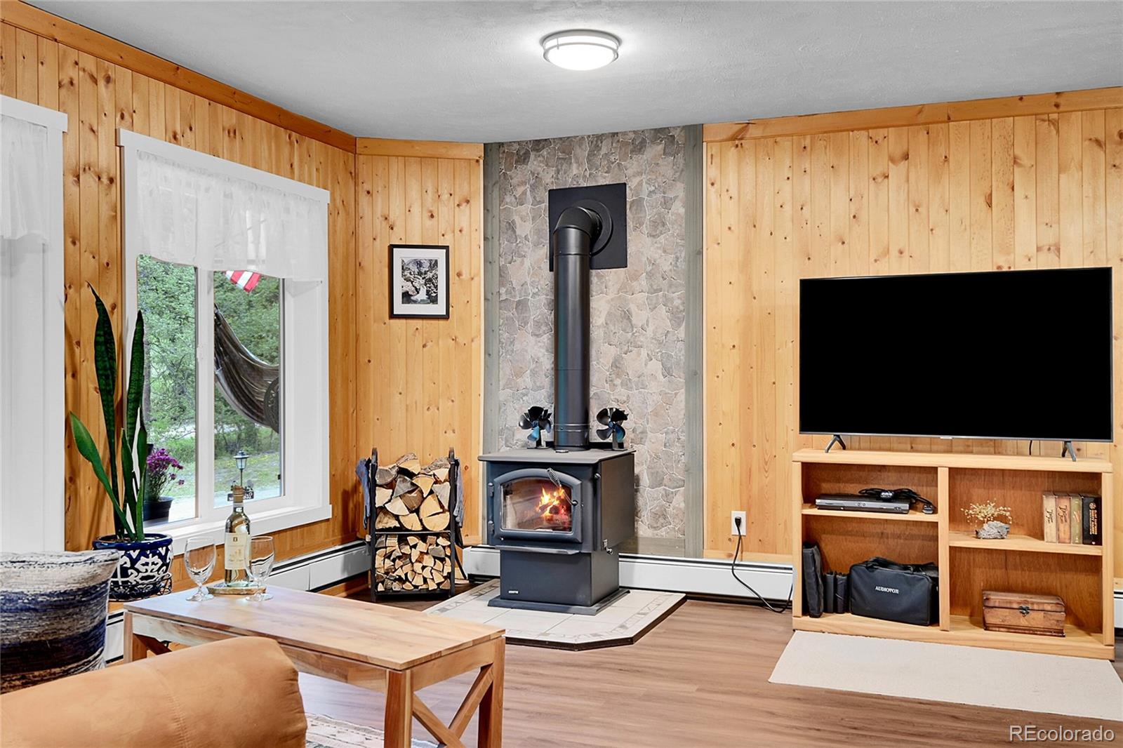 11182 Barney Gulch Road Conifer, CO 80433 - Photo 27 of 50 a living room with fireplace furniture and a flat screen tv