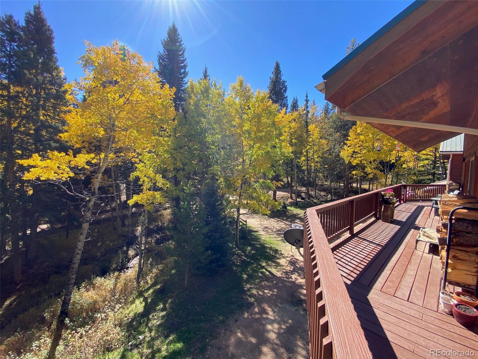 11182 Barney Gulch Road Conifer, CO 80433 - Photo 34 of 50 a view of a balcony with chairs and wooden floor