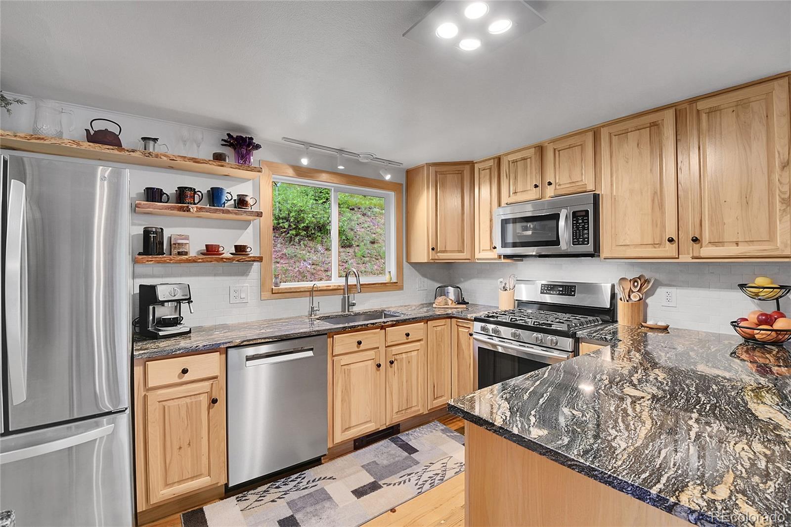11182 Barney Gulch Road Conifer, CO 80433 - Photo 5 of 50 a kitchen with stainless steel appliances granite countertop a sink stove and refrigerator