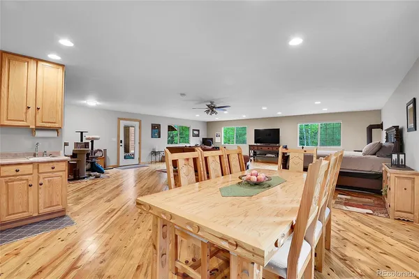 a view of a dining room with furniture a kitchen and chandelier