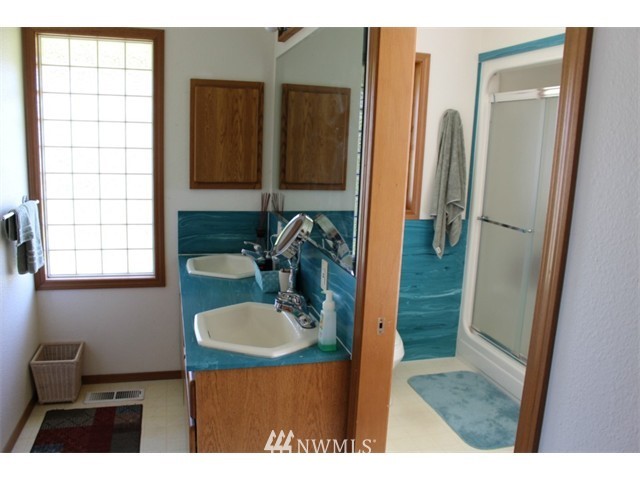 2127 Rice Road Chehalis, WA 98532 - Photo 13 of 25 a bathroom with a sink a mirror and a shower