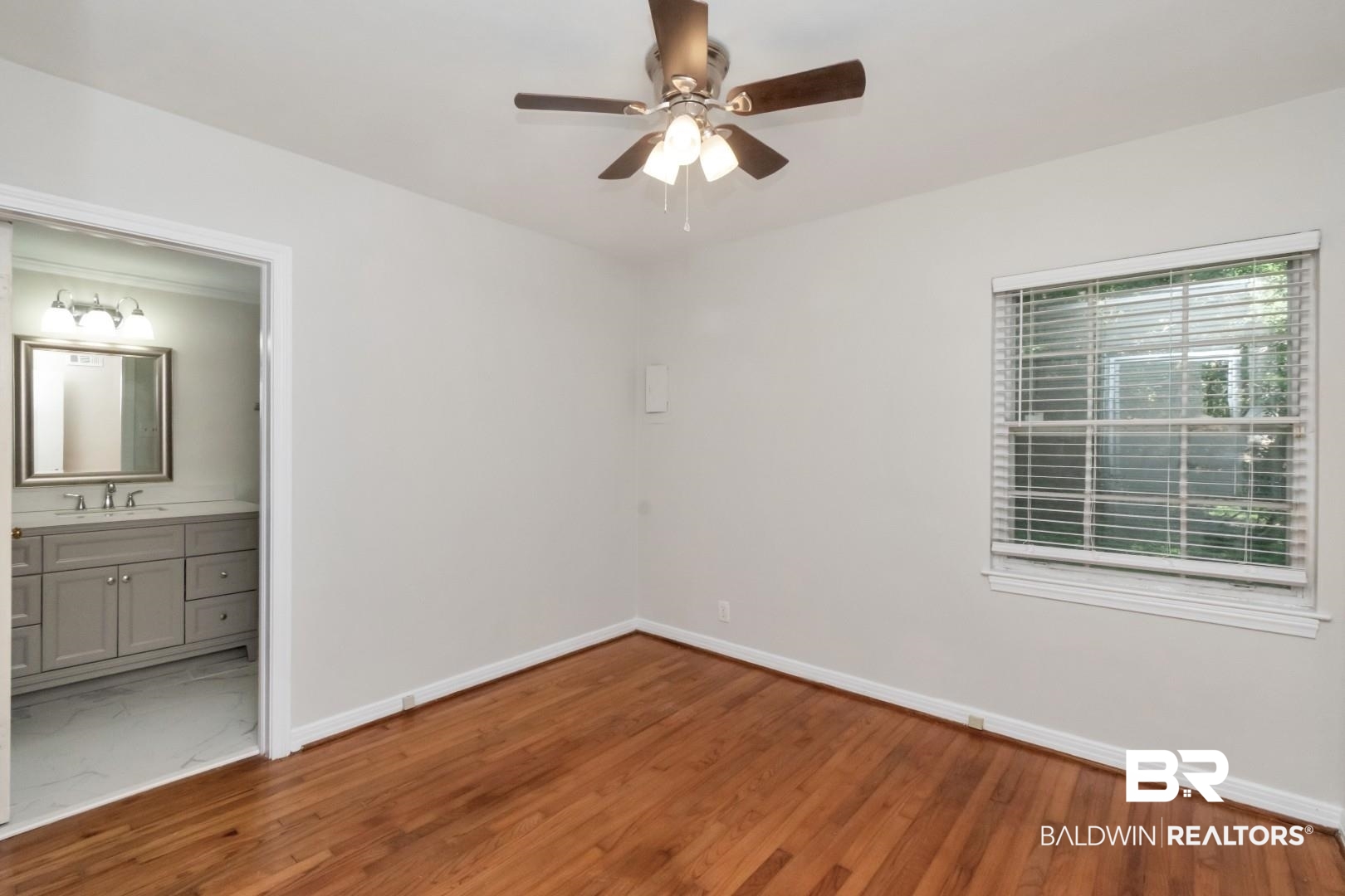 2105 Upham Court Mobile, AL 36607 - Photo 21 of 32 Unfurnished bedroom featuring wood finished floors, a ceiling fan, and connected bathroom
