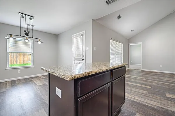a view of empty room with window and wooden floor