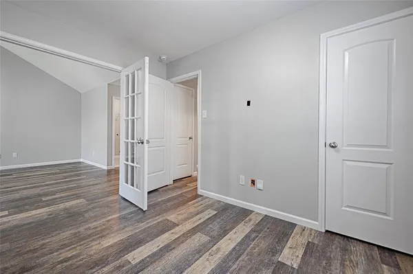 a view of a hallway with wooden floor and entryway