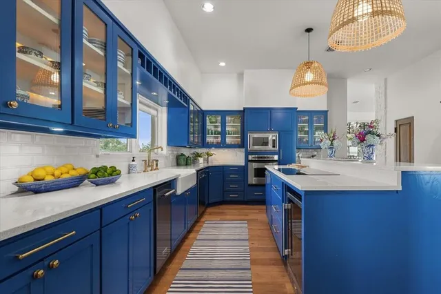 a kitchen with stainless steel appliances a sink and a wooden floors