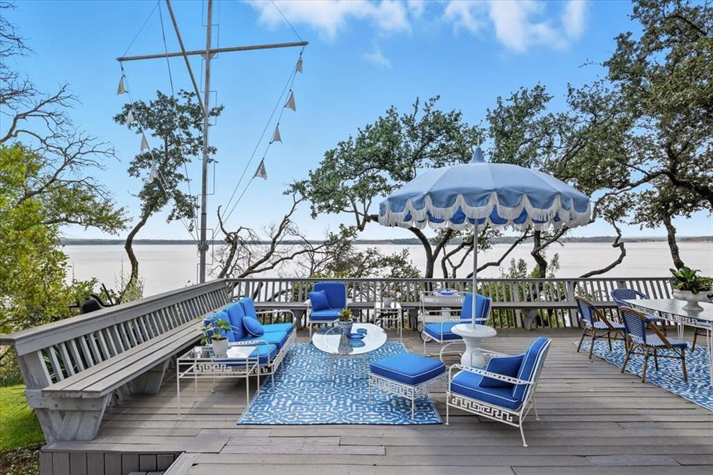 9308 Lechner Road Fort Worth, TX 76179 - Photo 26 of 40 a view of a roof deck with table and chairs a barbeque with wooden floor and fence