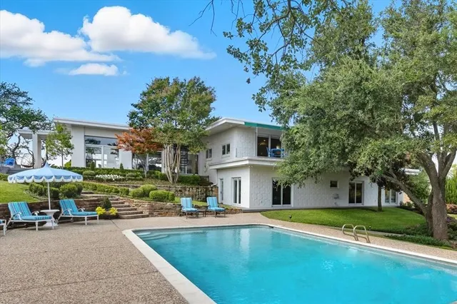 a view of house with outdoor space and swimming pool