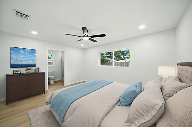 a bedroom with a large bed and a chandelier