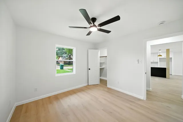 a view of a livingroom with wooden floor and a ceiling fan
