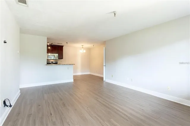 a view of a kitchen with wooden floor and a sink