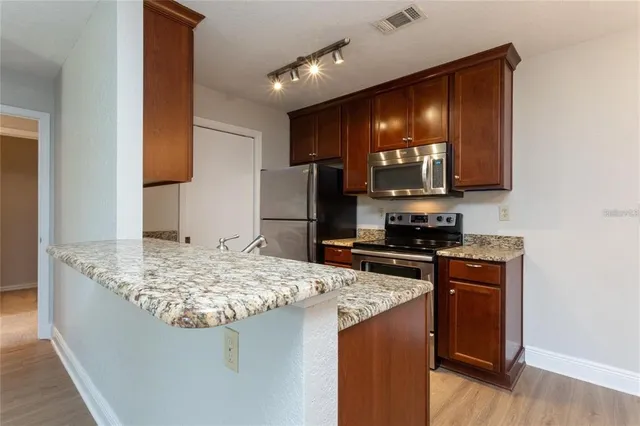 a kitchen with stainless steel appliances granite countertop a sink stove and refrigerator