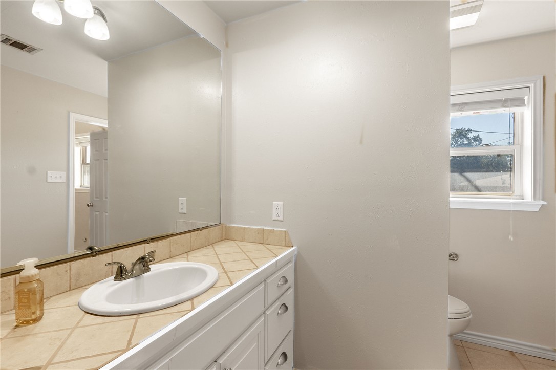 2316 Kent Street Bryan, TX 77802 - Photo 17 of 31 a bathroom with a granite countertop sink and a mirror